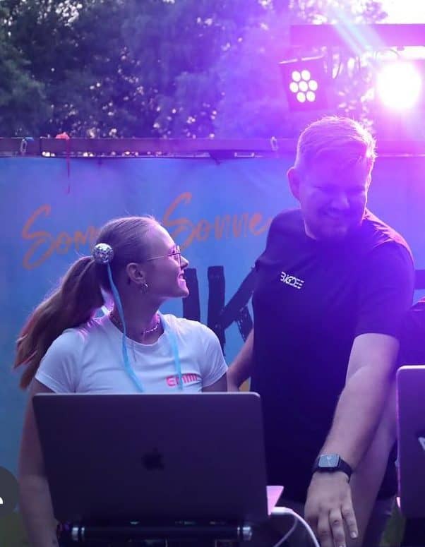 Emmi am DJ-Pult unter buntem Bühnenlicht