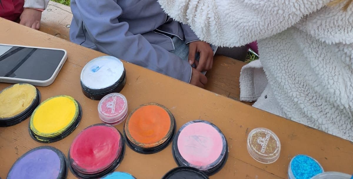Glitzer- und Farbdosen in Gelb, Rot, Orange und Rosa auf einem Tisch
