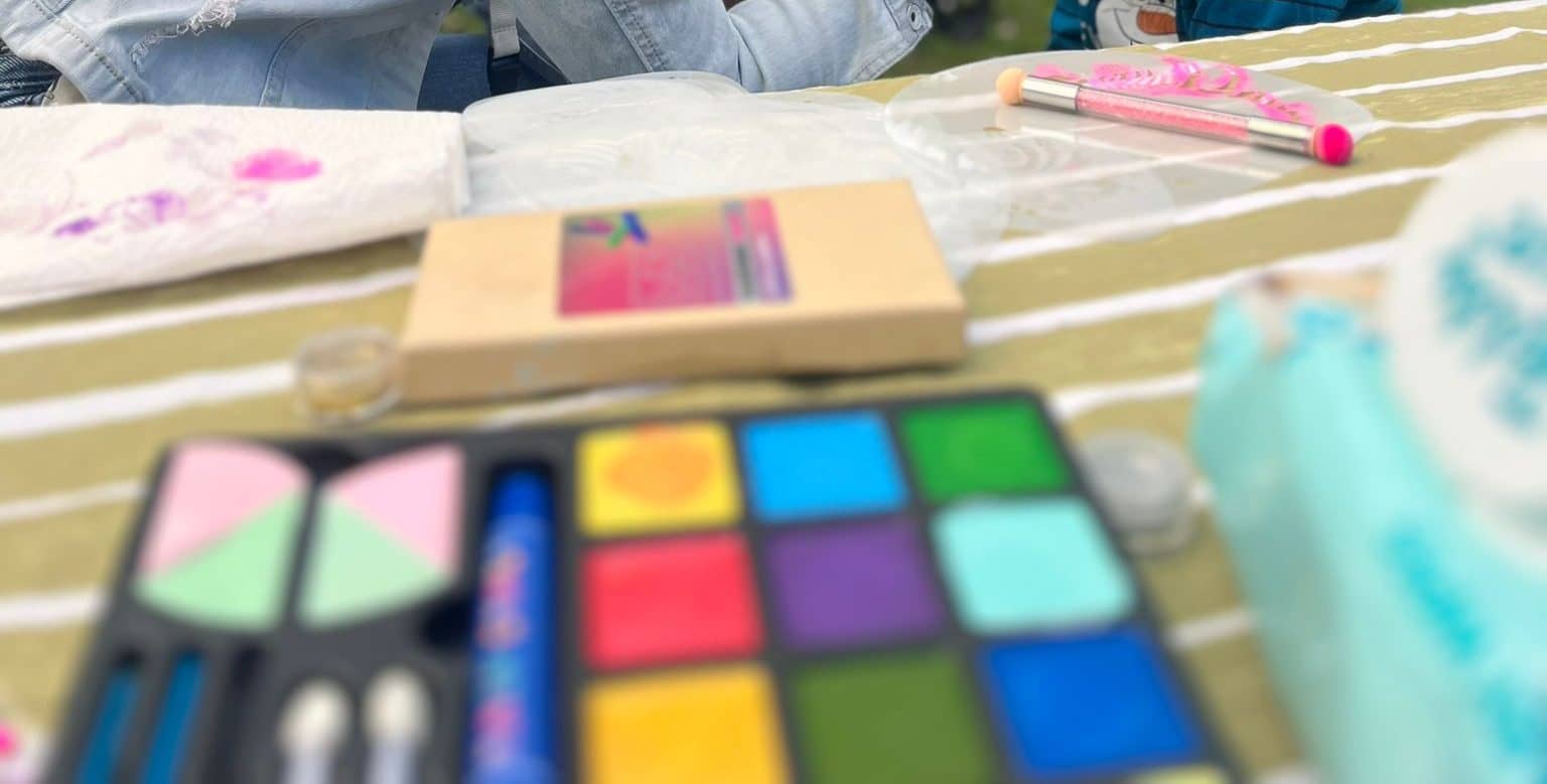 Schminkpalette mit zwölf bunten Farben und Pinseln